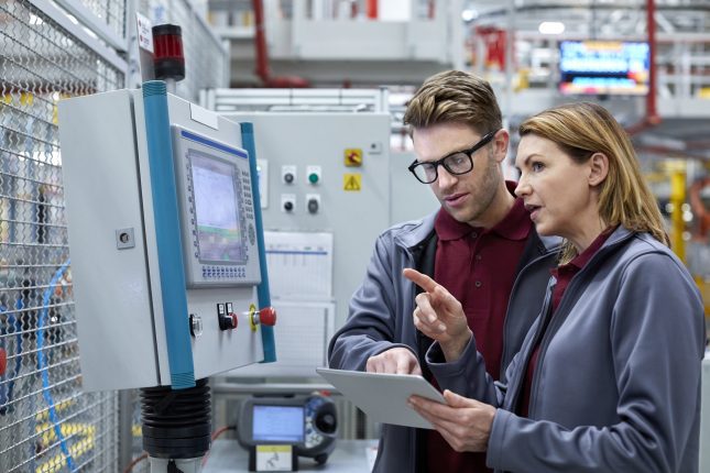 Car engineers with tablet computer looking away