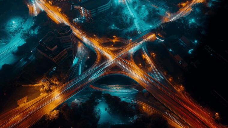 A stylised timelapse shot of a busy cloverleaf intersection at night, abstractly illustrating the complexity of supply chain transformation