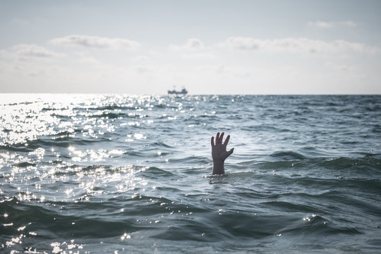 The hand of a drowning person reaches out of the surface of the sea. Preventive measures are more effective at saving lives, which is similar to how solving capacity problems before they occur is the best approach to planning