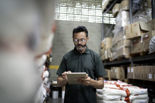 Manager using his tablet working in warehouse