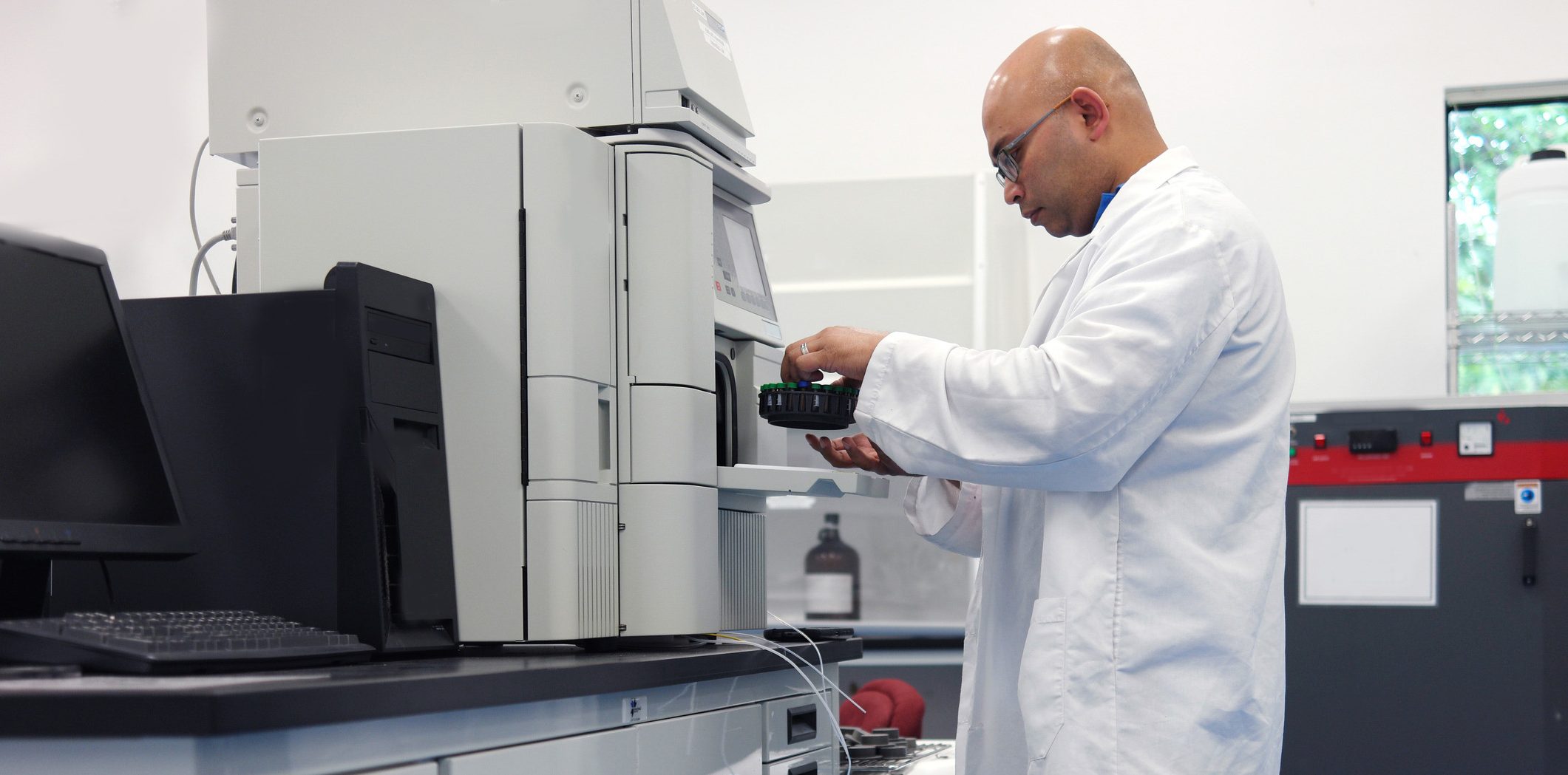 Man using an HPLC device to test samples in a lab, something made easier when the tests have been planned in advance