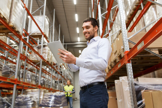 Supply chain professional with tablet in a warehouse